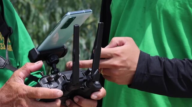 Using Controller with Smartphone, Hands Operating Agricultural Technology