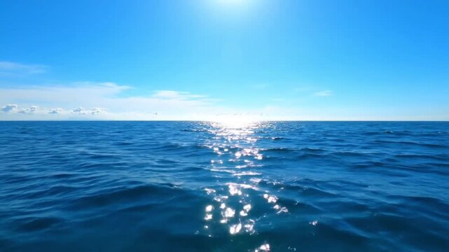 Bright sun path shimmering on the gentle deep blue sea waves under a clear azure sky, excellent establishing shot for travel, meditation, nature films, and summer advertisements.
