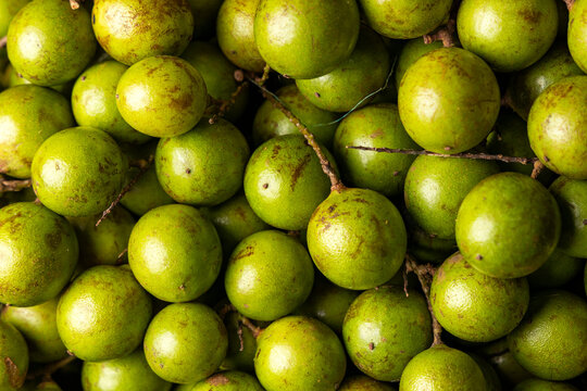 Fresh quenepas in a Colombian market square, showing their texture and natural appearance - Melicoccus bijugatus