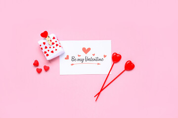 Naklejka premium Composition with greeting card, gift box and candles for Valentine's Day celebration on pink background