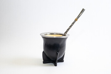 Traditional mate cup made from gourd covered with black leather and smooth metal rim, isolated on white background. Artisan South American drink container, product photo with copy space.