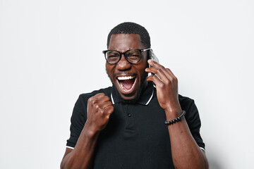 African American man with dark skin wearing glasses and black polo shirt talking on phone and...