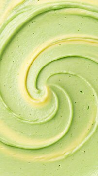 Video portrait 4k green and yellow matcha or avocado juice, Abstract close-up of light green creamy texture swirled into a spiral pattern. thick cosmetic body care or herbal substance background
