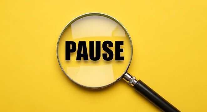 Magnifying glass focusing on the word pause against a yellow background
