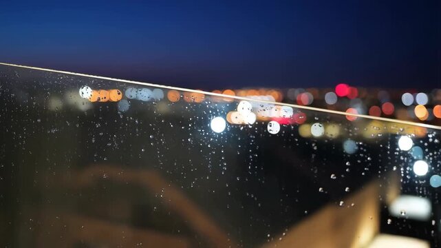 Rainy night traffic seen through wet windshield bokeh