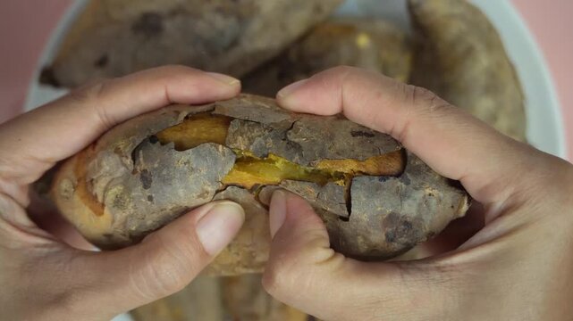 close-up of hands cutting yellow sweet potatoes and peeling their skin, concept of eating healthy food