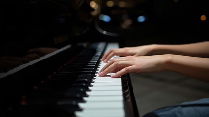 Fototapeta premium A close-up of hands playing a piano, capturing the elegance and artistry of music in a dimly lit environment.