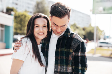 Fototapeta premium Smiling beautiful woman and her handsome boyfriend. Woman in casual summer clothes. Happy cheerful family. Female having fun. Sexy couple posing in the street at sunny day