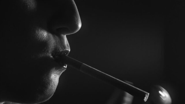 Macro close-up of a woman lighting a cigarette and exhaling smoke between her lips (Slow Motion / Black & White).