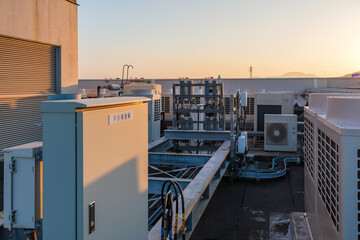 夕暮れ時の商業施設屋上に設置された受電・制御設備