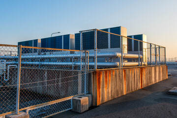 フェンス越しに見る建物の空調インフラと冷却システム