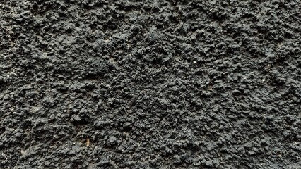Fototapeta premium Close-up macro of black and white wool fabric texture and dark leather material on a rough gray concrete stone surface with a grunge cement structure.