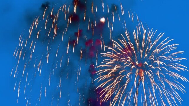A dazzling display of fireworks exploding in a vibrant, clear night sky with various shapes and patterns