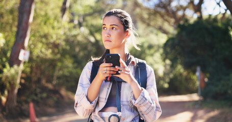 Obraz premium Phone, navigation and woman on path for hiking, network and guide in online direction. Travel, route and female person in forest with tech, map tracking and location search on outdoor adventure.