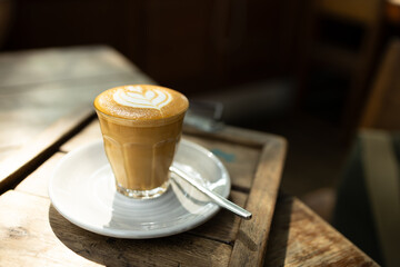 Cup of coffee latte art on wood table.