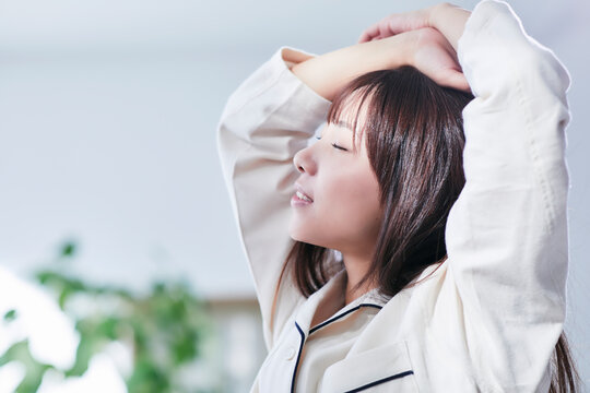 ベッドルームでストレッチをするパジャマを着た若い女性