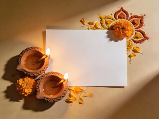Diwali diya lamps, marigold flowers, and rangoli powders on a textured background