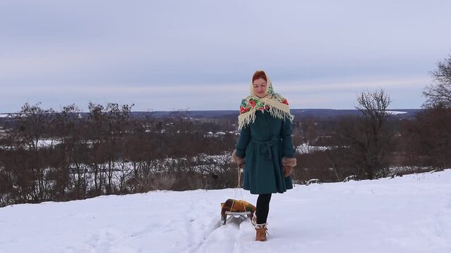 Joyful young woman during a winter walk in nature. Snow, activity, sincere emotions and seasonal mood.