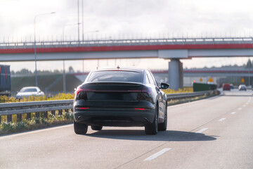 Black luxury car moving sunny landscape
