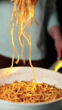 Woman mixing pasta with minced meat in pan