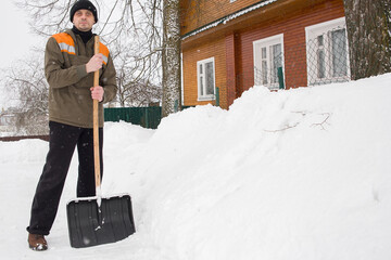 A European man shoveling snow near his home.