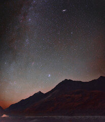 Night sky with stars against the backdrop of a mountain range.