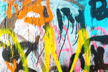 Obraz premium Abstract graffiti street art in bright orange, yellow, pink, blue on textured wall. Urban 90s, Y2K style, fluorescent paint, dripping effect. Background texture, pattern, flyer, web, site