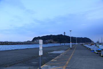夕暮れ時の青みかかった江ノ島近くの片瀬漁港の様子