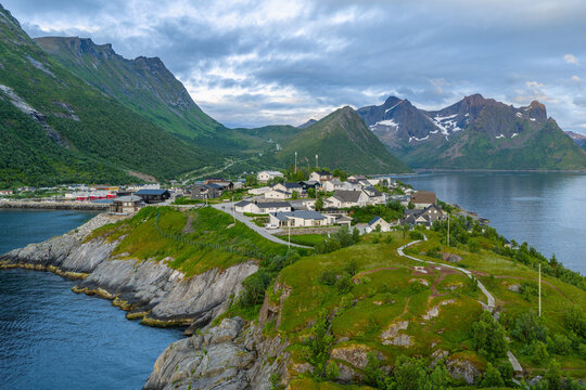 12 july 2025, Hus&oslash;y, Norway. Aerial, drone view of little villate Husoy and island in &Oslash;yfjorden fjord during sunset. Beautiful nature, mountains surrounding fjord, wonderful golden reflection from the