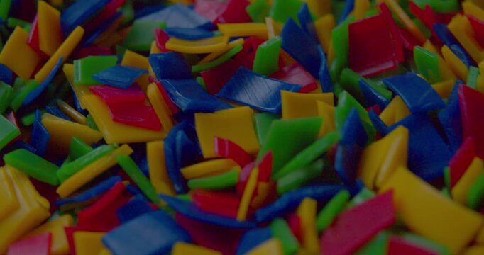 Footage of small vivid plastic pieces prepared for recycling purposes.
