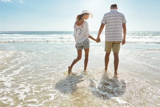 Love, holding hands and back with couple at beach for bonding, support and summer vacation. Anniversary holiday trip, travel adventure and ocean with man and woman outdoor for connection on date