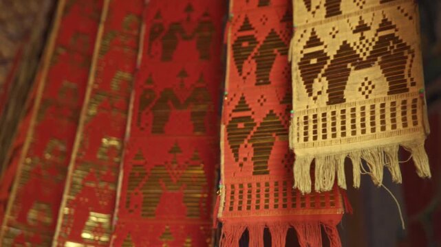 Colorful traditional Lanna fabric flags hanging inside a temple, gently moving in the wind, creating a calm spiritual atmosphere and showcasing northern Thai cultural heritage. 4k video footage