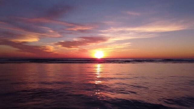 Spectacular golden sunset over the ocean horizon with stunning pastel clouds and glistening sun path, perfect for travel, nature documentaries, and peaceful meditation videos.