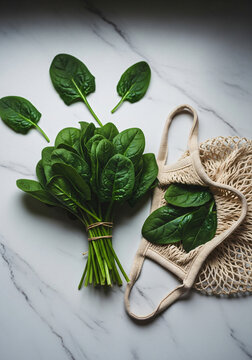 Vertical shot of Fresh green spinach leaves with beige mesh shopping bag