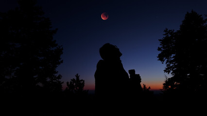 Fototapeta premium Amateur astronomer using binoculars for observing stars, planets, Moon and other celestial objects.