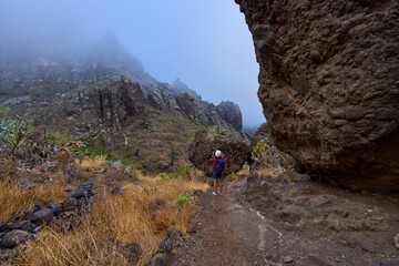 Woman photographing Masca canyon walls