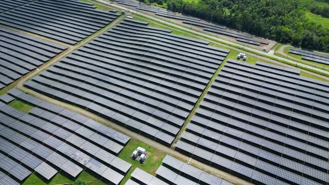 Low-altitude drone pass revealing massive solar panel arrays stretching across rural Palauig, Zambales under clear tropical skies.