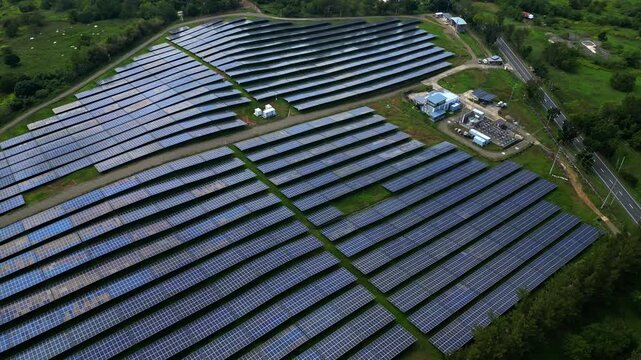 Distant aerial view showing the full scale of the solar panel installation across open land in Palauig, Zambales.