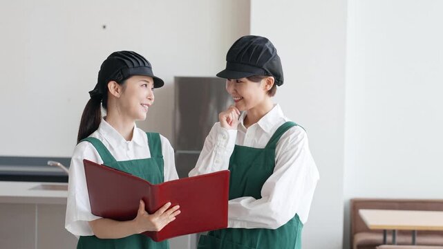 店内でファイルを見る飲食店店員