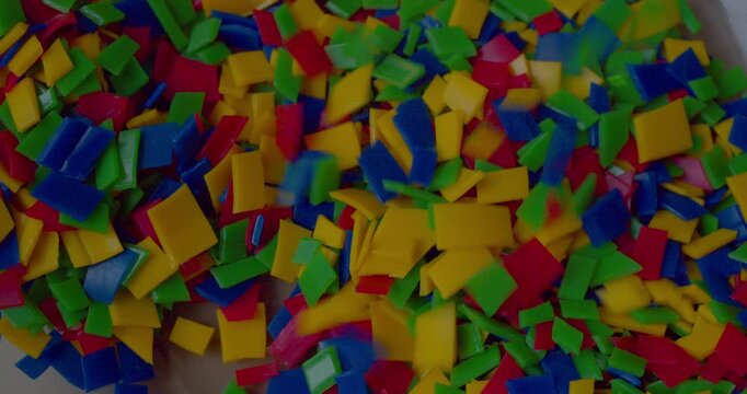 Lots of small brightly pieces of shredded household plastic destined for recycling.