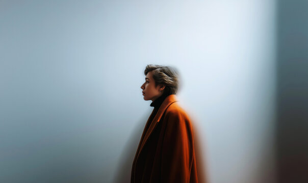 Artistic Side Profile Portrait of Young Man Against White Wall With Abstract Light Reflections and Orange Glow in Dreamy Atmosphere