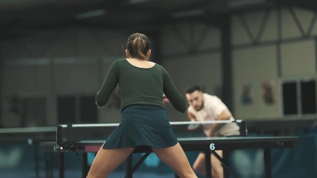 Female athlete hitting the ball during table tennis match