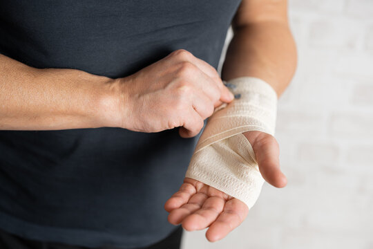 Man's hand wrapping elastic bandage