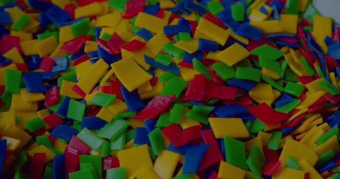 Footage of small vivid plastic pieces prepared for recycling purposes.