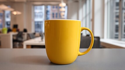Fototapeta premium Close-up of a vibrant yellow ceramic coffee mug sitting on a desk in a blurred modern office setting