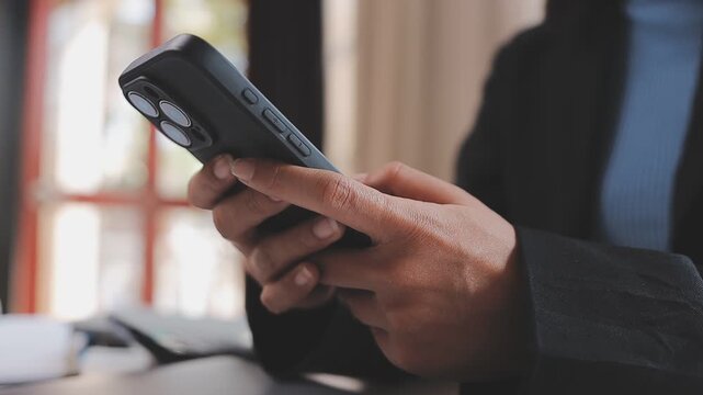 Young casual Businessman holding and using smartphone for sms messages, hipster man typing touchscreen cell phone in the cafe. business, lifestyle, technology and Social media network concept
