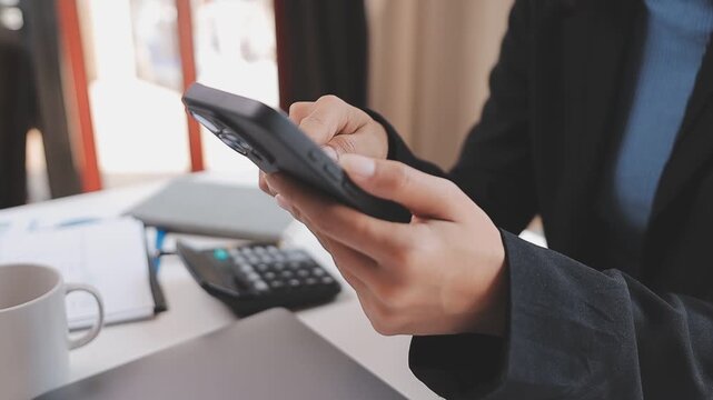 Young casual Businessman holding and using smartphone for sms messages, hipster man typing touchscreen cell phone in the cafe. business, lifestyle, technology and Social media network concept