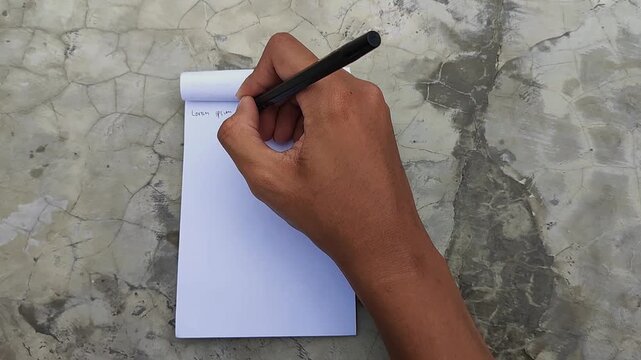 hand with a pen writing on a blank paper