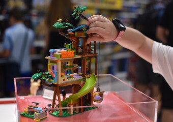 Fototapeta premium The child is playing with a Lego house