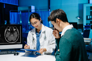 Fototapeta premium Female doctor reviewing brain MRI and notes during medical consultation with stressed male patient. Neurology diagnosis, mental health care and modern healthcare technology.